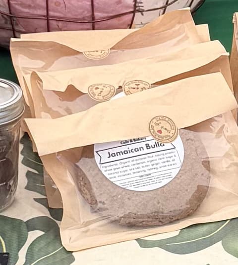 A round Jamaican bulla cake in a kraft bag with a Garden Brew label